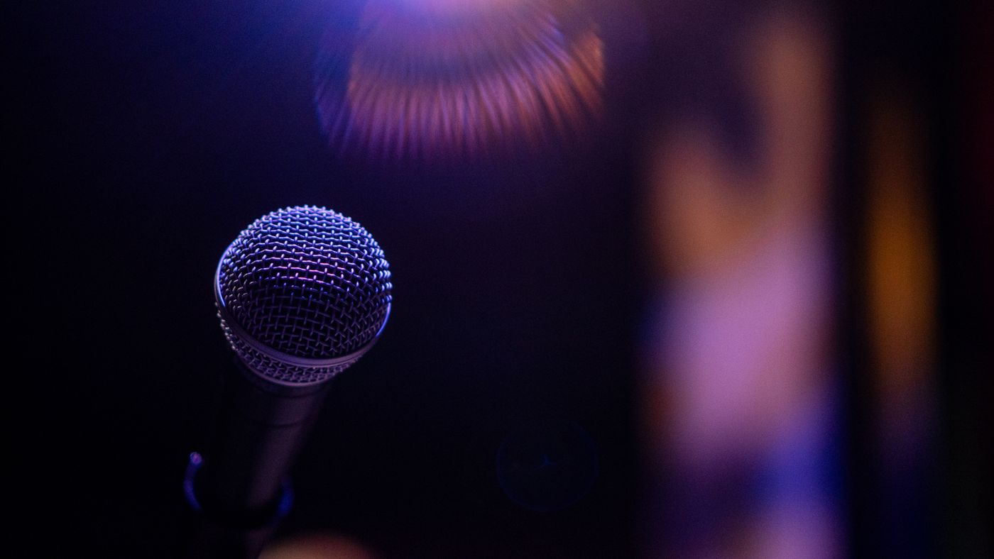 A single microphone with subtle coloured light; illustrative photography